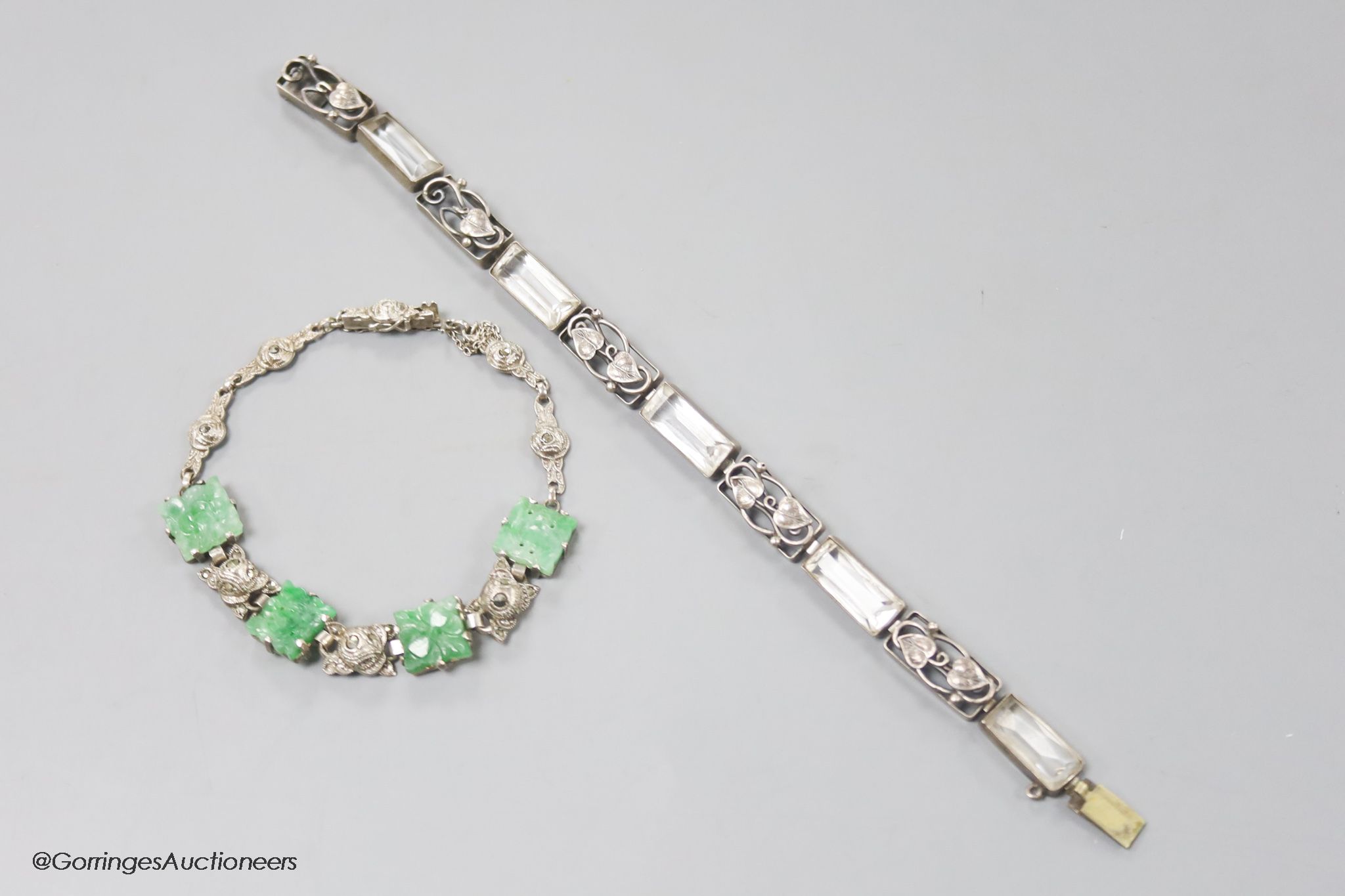 A white metal and carved jade set bracelet and one other bracelet.